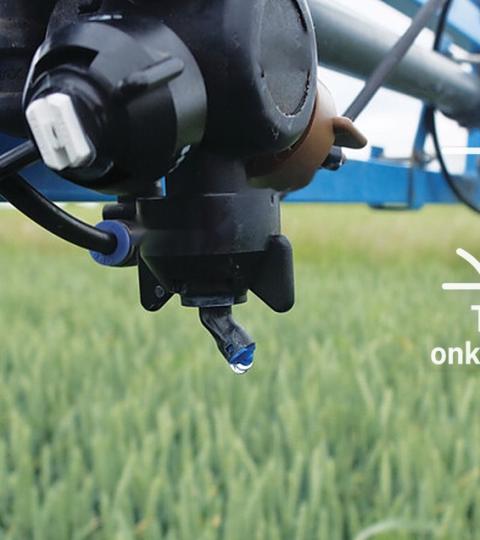 Landbouwdrone sproeit boven groen veld; tekst: “Tijdens de onkruidbestrijding”.